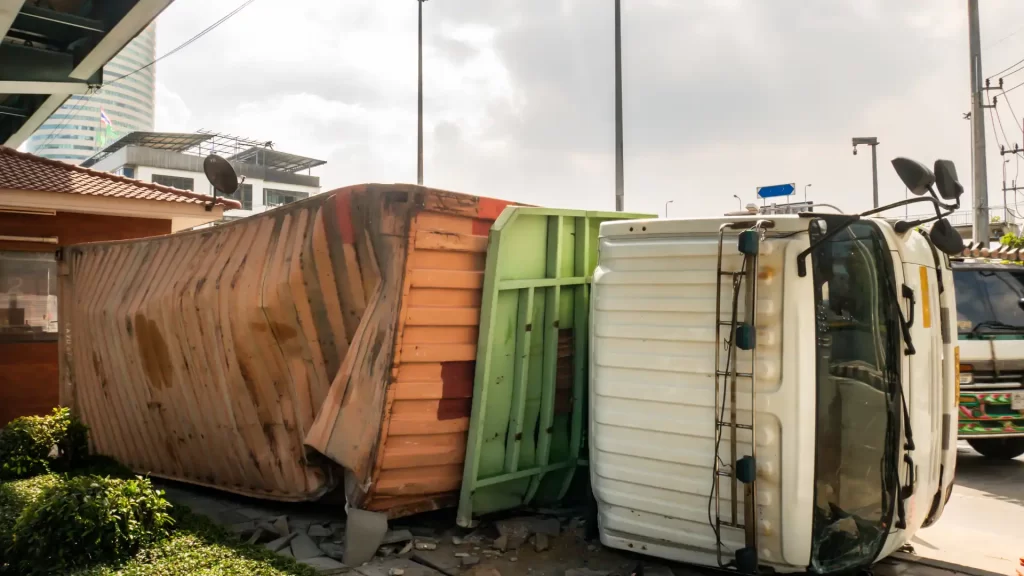 A truck with shipping container rolled over on its side, exemplifying the question, what causes truck rollover accidents in georgia?